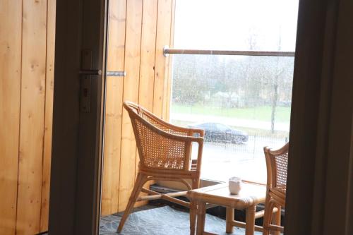 two chairs and a table in front of a window at WijkD in Leende