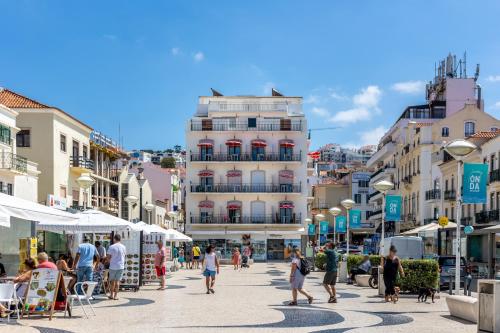 a group of people walking on a street with buildings at Carepa Suites -Nazaré, Steps from the Beach in Nazaré