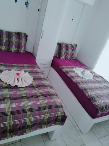 two beds in a room with purple sheets at BELKA GOLF RESİDENCE Deluxe apt Poolside BELEK in Belek