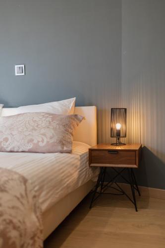 a bed with a night stand with a lamp on it at SPACIEUX STUDIO HAUT PLAFOND PROCHE MONACO in Beausoleil