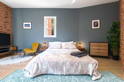 - une chambre avec un grand lit et un mur bleu dans l'établissement SPACIEUX STUDIO HAUT PLAFOND PROCHE MONACO, à Beausoleil