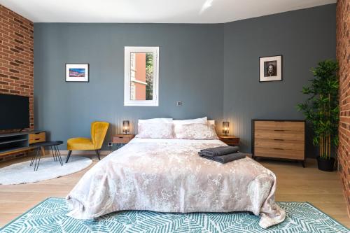 sypialnia z dużym łóżkiem i niebieską ścianą w obiekcie SPACIEUX STUDIO HAUT PLAFOND PROCHE MONACO w mieście Beausoleil