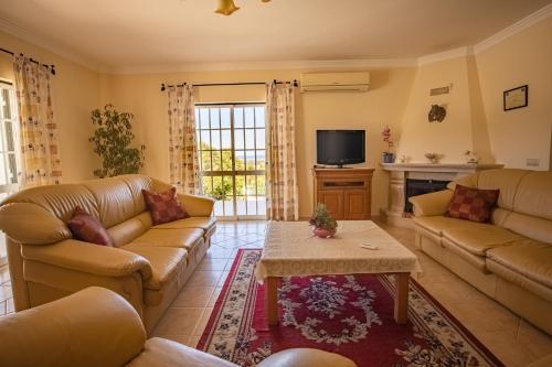 a living room with couches and a tv at Villa Agapito - Sea view - AC - BY BEDZY in Galé