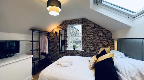 a bedroom with a bed with a stone wall at ☆ The Cottage - Cosy 1 bedroom, central location ☆ in Harrogate