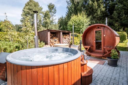 a hot tub and a sauna in a garden at Hotel SLUNEČNÁ LOUKA in Lipno nad Vltavou
