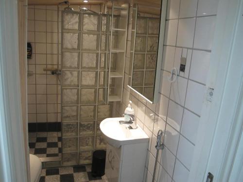 a bathroom with a sink and a shower with a mirror at Guesthouse Sharon Aarhus in Aarhus