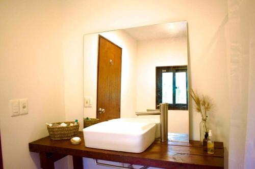 a bathroom with a white sink and a mirror at La casa del monte - Naturaleza y cielo nocturno in Villa Serrana