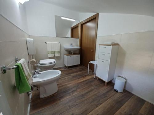a white bathroom with a sink and a toilet at L'Acero di STALL in Viterbo