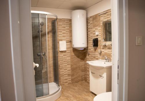 a bathroom with a shower and a toilet and a sink at Hotel Oppium Restaurant & Garden in Ruse