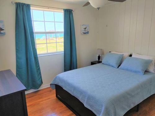 1 dormitorio con cama con sábanas azules y ventana en Melbourne Beach Ocean Front house on 1.2 acres, en Melbourne Beach