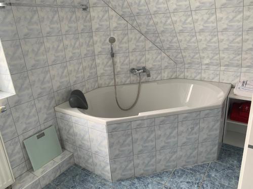 a bath tub with a shower in a bathroom at ruhige drei Zimmer Eigentumswohnung 