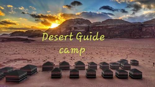 Desert guide camp في وادي رم: مجموعة من الأسرة على الشاطئ عند غروب الشمس
