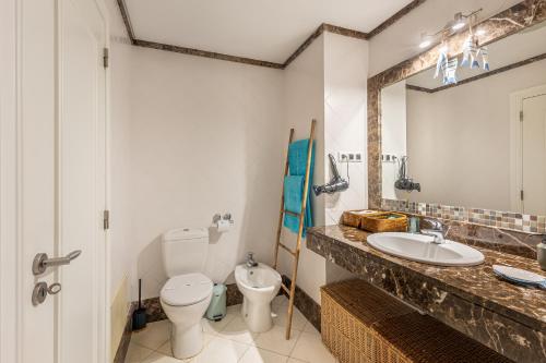 a bathroom with a sink and a toilet and a mirror at Atlantic Ocean View Apartment in Funchal