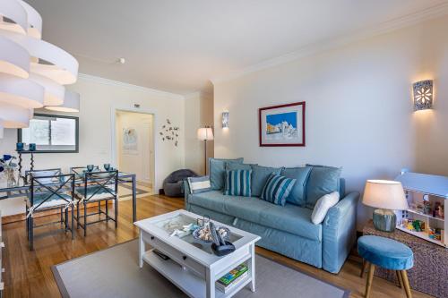 a living room with a blue couch and a table at Atlantic Ocean View Apartment in Funchal