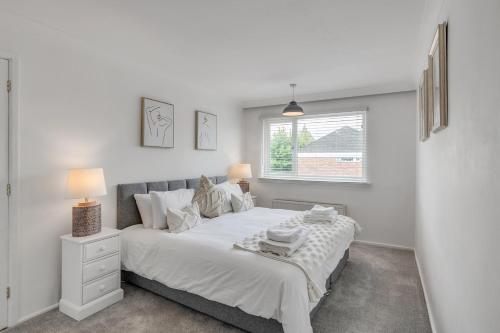 a bedroom with a large white bed with a window at Grove Avenue in Norwich