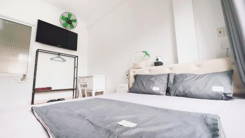 a bedroom with a bed and a tv on the wall at Cuccu homestay in Kiến An