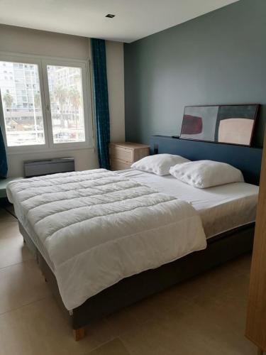 une chambre avec un grand lit avec deux oreillers dans l'établissement Le Méditerranée 1er Ligne vue mer classe 3, à Canet