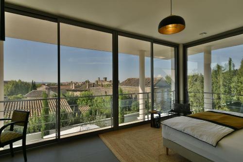 Monte Alta في صالون دو بروفانس: غرفة نوم بسرير ونوافذ زجاجية كبيرة