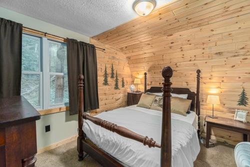 a bedroom with a bed and a wooden wall at Hidden River Cabin in Frankfort