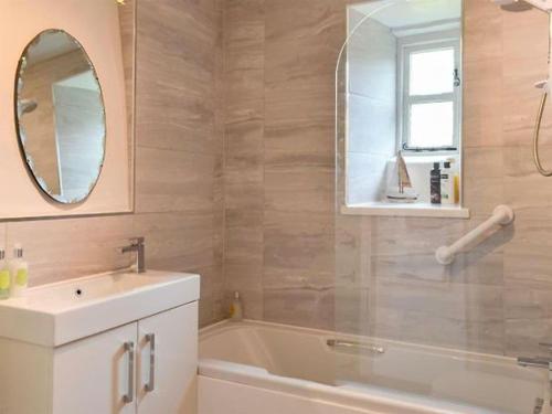 een badkamer met een wastafel, een bad en een spiegel bij Crosse Chance Cottage - Idyllic, beautiful, traditional cottage to love - Wood burner in Taddington