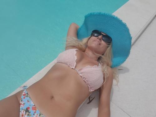 a woman in a bikini and a blue hat and sunglasses at Nonna Anita Palace Narni in Narni