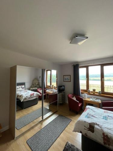 a bedroom with a bed and a living room at Doura Lodge in Inverness
