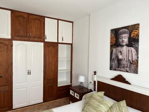 ein Schlafzimmer mit einem Bett und einer Statue an der Wand in der Unterkunft Casa Escanfraga I in Villaverde
