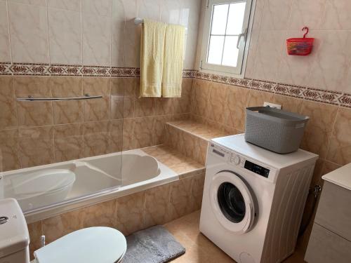 a bathroom with a washing machine and a bath tub at Casa Escanfraga I in Villaverde
