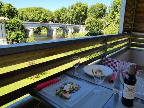 コンフォランにあるLogis Hôtel Emeraudeのテーブル(一皿の食べ物とワイングラス付)