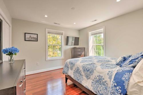 a bedroom with a blue and white bed and two windows at Spacious DC Family Home 6 Mi to Capitol Hill in Washington, D.C.