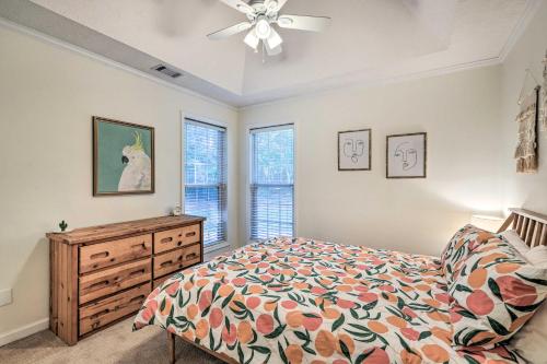 a bedroom with a bed and a dresser and windows at Fayetteville Retreat with Hot Tub and Fenced Yard in Fayetteville