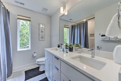 a bathroom with a sink and a toilet and a mirror at Contemporary Raleigh Home about 2 Mi to Downtown! in Raleigh