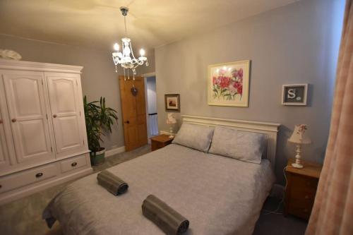 a bedroom with a large bed and a chandelier at Perfect for Snowdon. Groups, families+dogs welcome in Llanberis