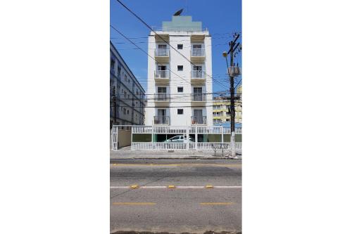 una calle vacía frente a un edificio blanco en Apartamentos Enseada Guaruja, en Guarujá