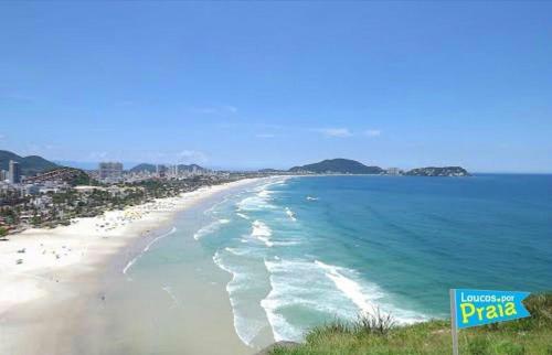 a view of a beach with people and the ocean at Apartamentos Enseada Guaruja in Guarujá