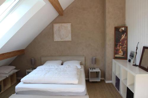 ein Schlafzimmer mit einem weißen Bett im Dachgeschoss in der Unterkunft Gite combes soleil calme et nature in Le Sappey-en-Chartreuse