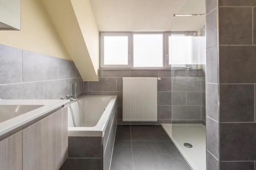 a bathroom with a bath tub and a sink at L'eau de vie in Alveringem