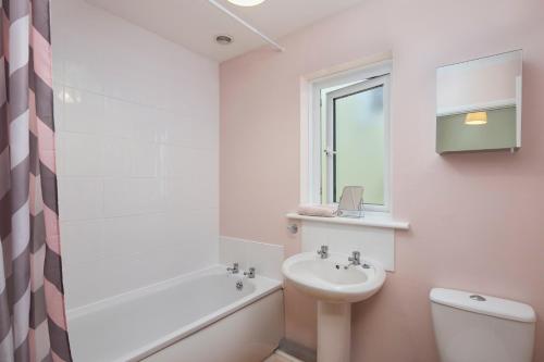 een badkamer met een wastafel, een toilet en een bad bij Bossell Cottage Devon in Buckfastleigh
