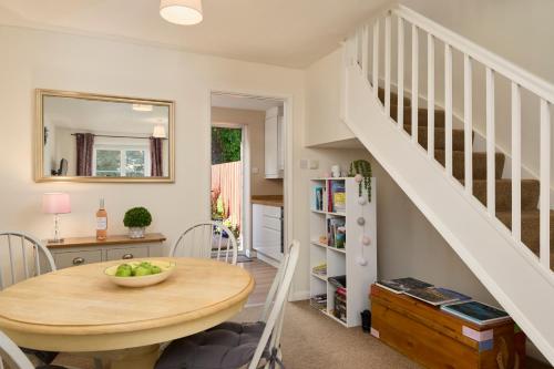 a kitchen and dining room with a table and a staircase at Bossell Cottage Devon in Buckfastleigh
