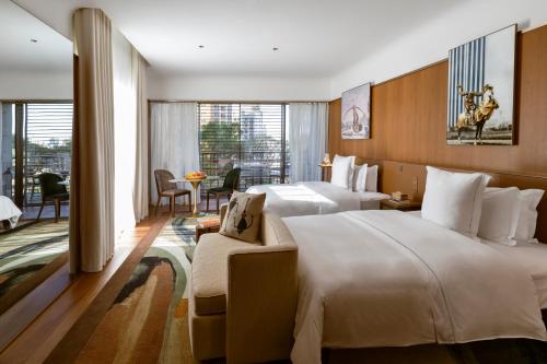 a hotel room with two beds and a couch at Rosewood São Paulo in Sao Paulo