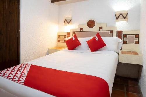 1 dormitorio con 1 cama grande con almohadas rojas en OYO Posada Astrud,Cuetzalan en Cuetzalán del Progreso