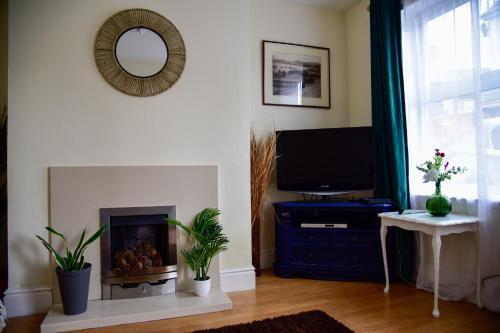 a living room with a fireplace and a tv at 6 Bryn Terrace, Conwy in Conwy