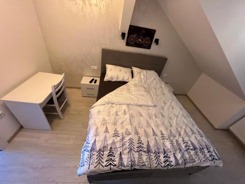 a small bedroom with a bed and a desk at Lux Apartman Rudnik in Rudnik Kačerski