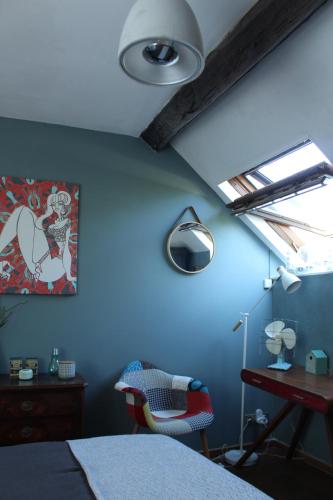 a bedroom with blue walls and a bed and a window at LE PRESBYTERE in Chasnay