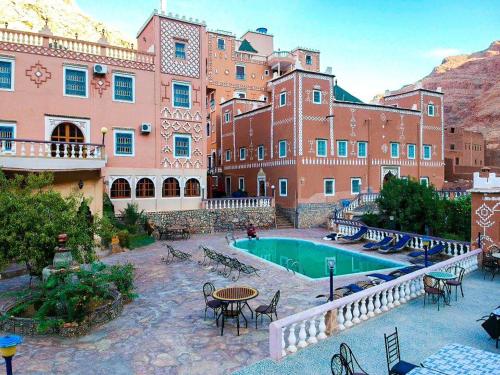 廷吉尔Hotel taborihte的享有带游泳池和桌椅的建筑的景致。