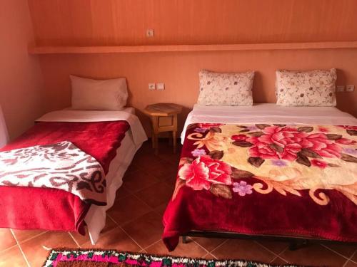 two beds sitting next to each other in a room at Hotel taborihte in Tinerhir