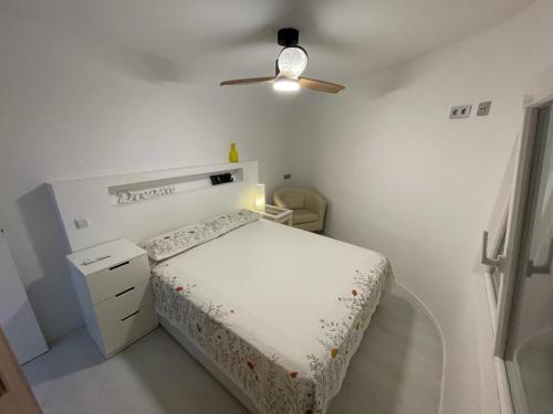 a white bedroom with a bed and a ceiling fan at Valencia Old Town EL CARMEN. in Valencia