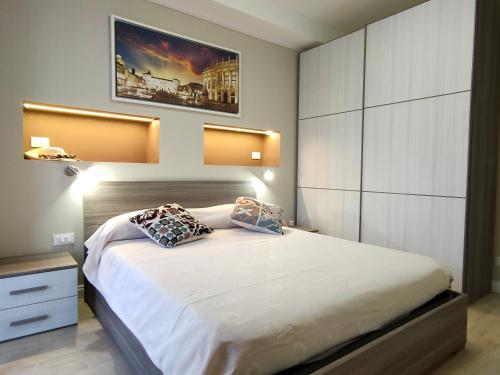 a bedroom with a large white bed with two pillows at DOMUS LINGOTTO in Turin