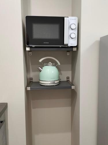 a tea pot and a microwave on a shelf at DOMUS LINGOTTO in Turin