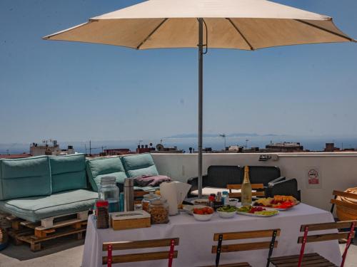 stół z jedzeniem i parasol na dachu w obiekcie Aguere Nest Hostel w mieście La Laguna